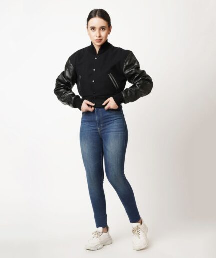 A stylish black wool and leather letterman crop top jacket with rib knit collar and cuffs, featuring snap button closure and two open hem side pockets.